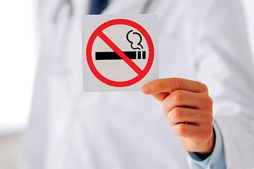 Healthcare provide holding a no smoking sign